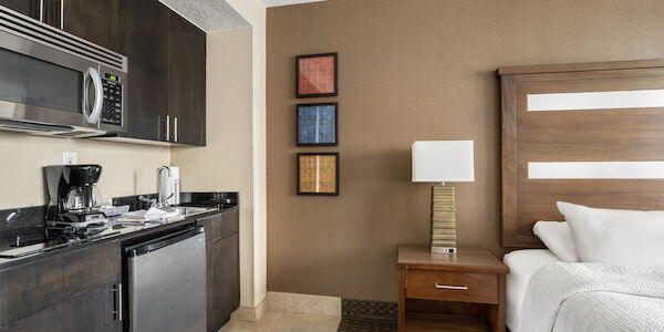 A hotel room with a kitchenette and a bed